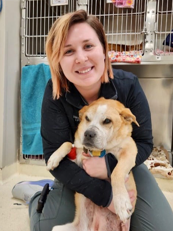 female vet tech posing with dog