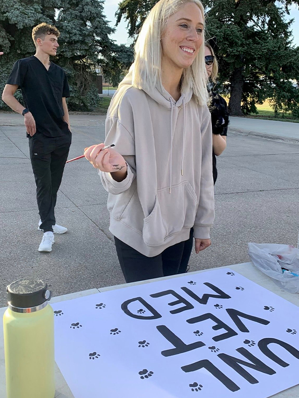 Blonde female painting sign
