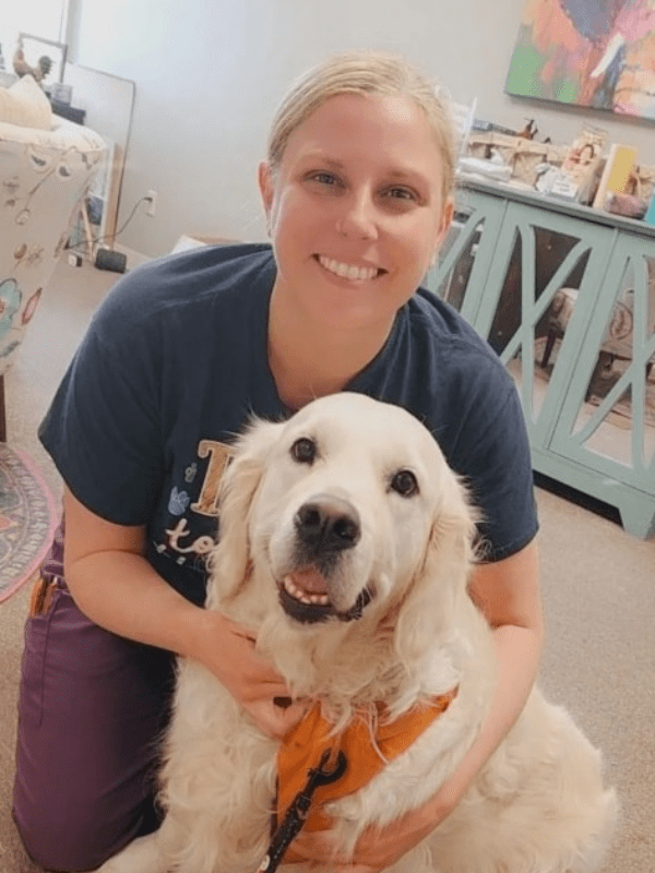 Blonde female posing with white haired Labrador retriever